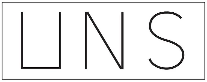 Early UNS logo direction: thin UNS letters inside a rectangular frame