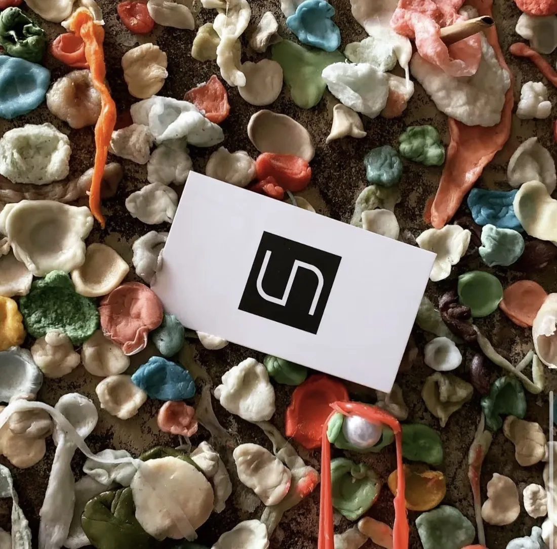 A UNS business card pressed into the Pike Place Market gum wall